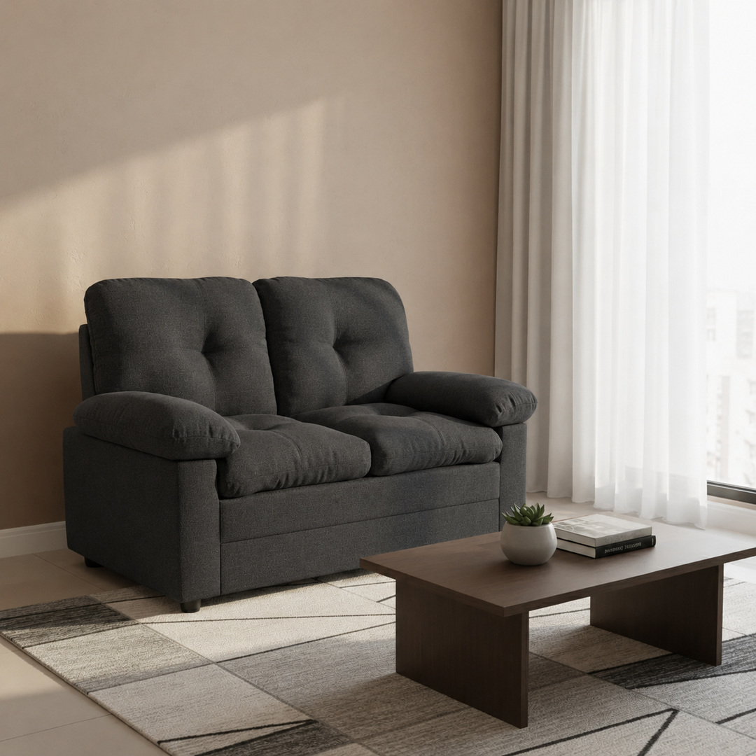 Dark gray tufted loveseat sofa in modern living room with coffee table and rug