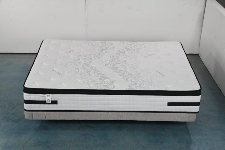Modern queen-size mattress with white quilted top and floral pattern on blue floor