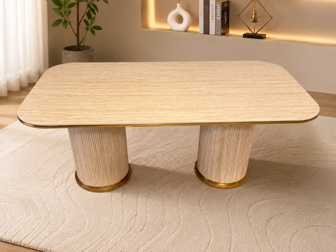 Modern rectangular dining table with light wood finish and gold-trimmed fluted legs in cozy living space