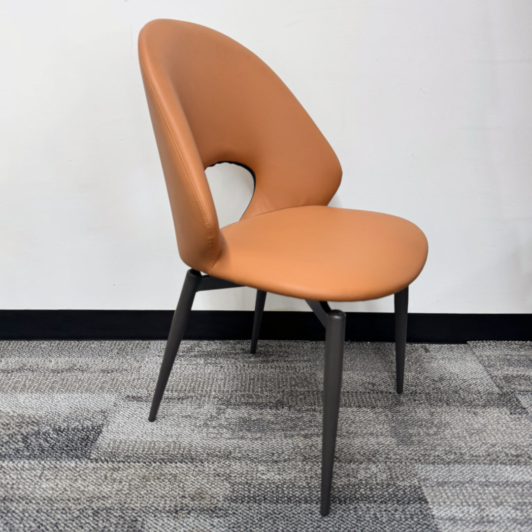 Modern tan upholstered dining chair with unique cut-out backrest and black metal legs