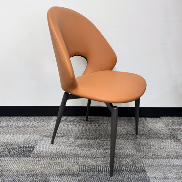 Modern tan upholstered dining chair with unique cut-out backrest and black metal legs