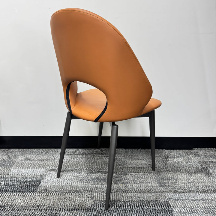 Modern brown upholstered dining chair with black metal legs on grey carpet