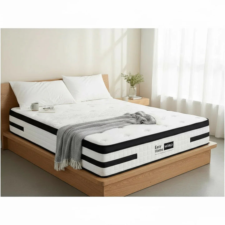 Modern bedroom with a white mattress on a wooden bed frame, cozy pillows, throw, and natural light