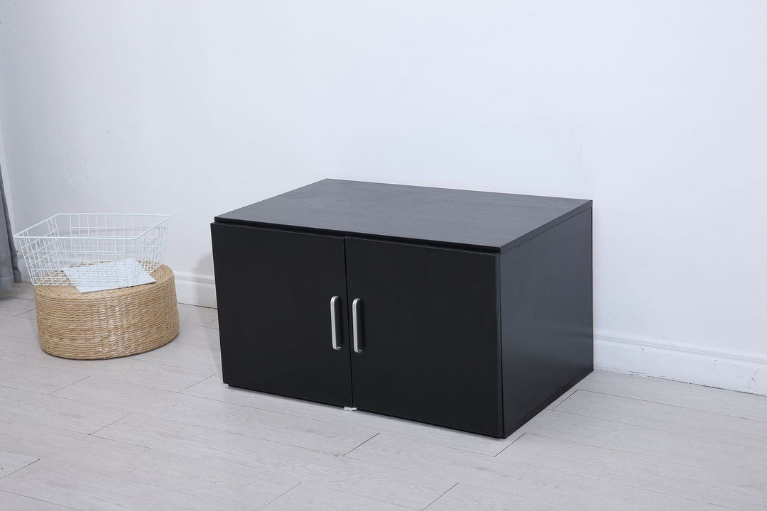 Modern black wooden storage cabinet with double doors and silver handles in a minimalist room