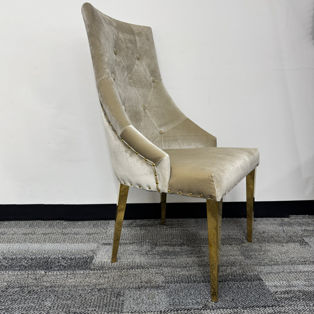 Velvet accent chair with tufted backrest and gold metal legs on carpeted floor