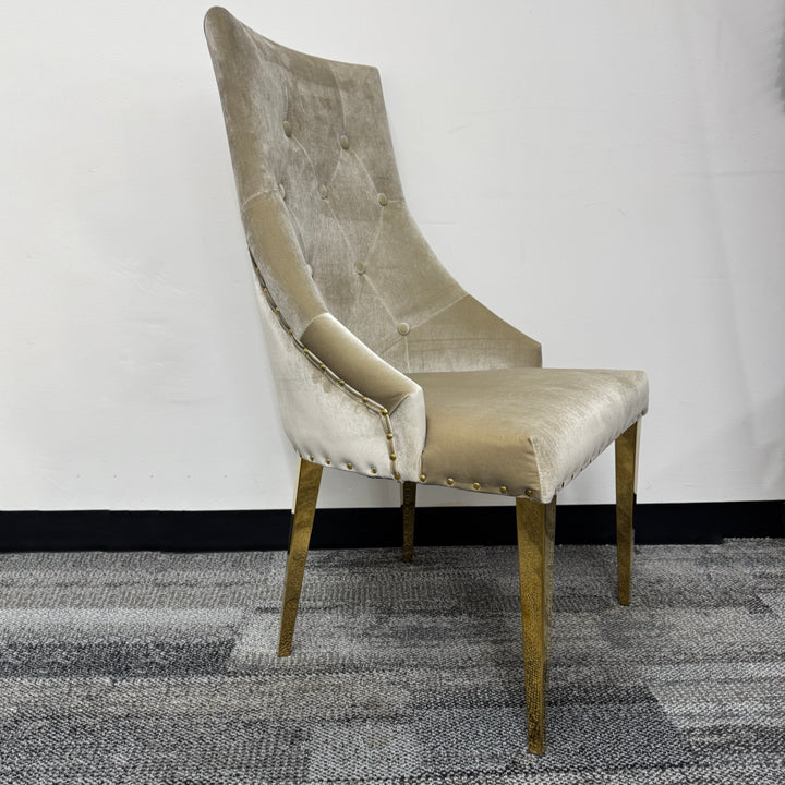 Velvet accent chair with tufted backrest and gold metal legs on carpeted floor