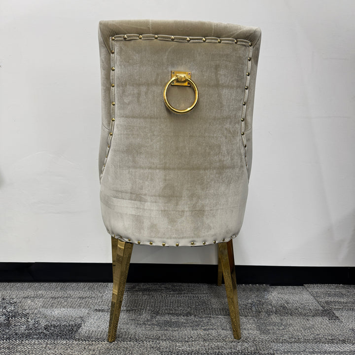 Beige velvet chair with gold metal legs and decorative gold ring on the backrest